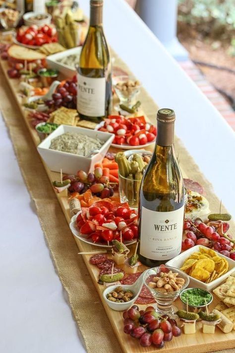 a table filled with lots of food and bottles of wine on top of each other