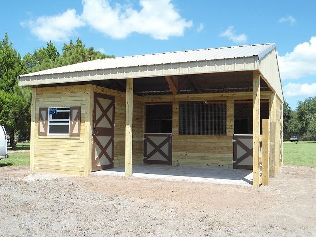 a horse barn with two stalls in the front and one stall on the other side