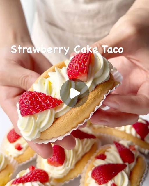 a person holding a strawberry cake taco in front of some other cupcakes