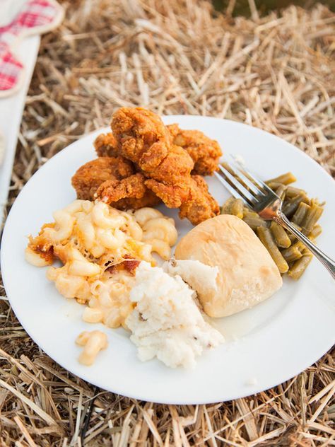 a white plate topped with chicken, mashed potatoes and green beans next to a fork