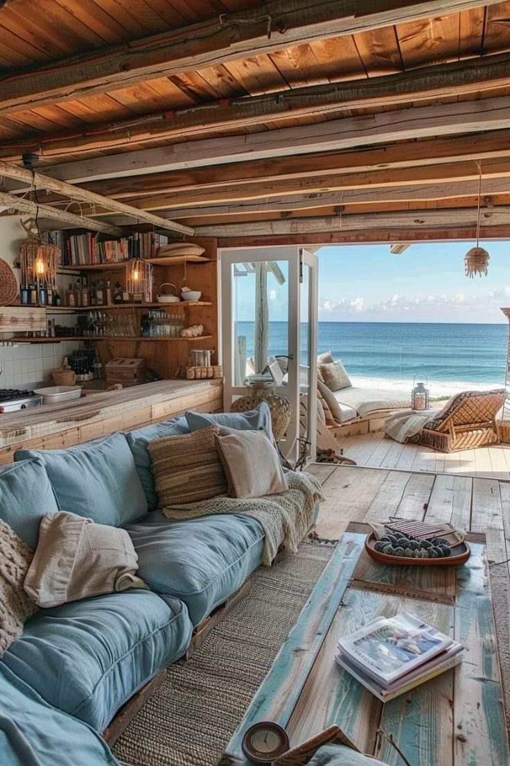 a living room filled with furniture next to the ocean