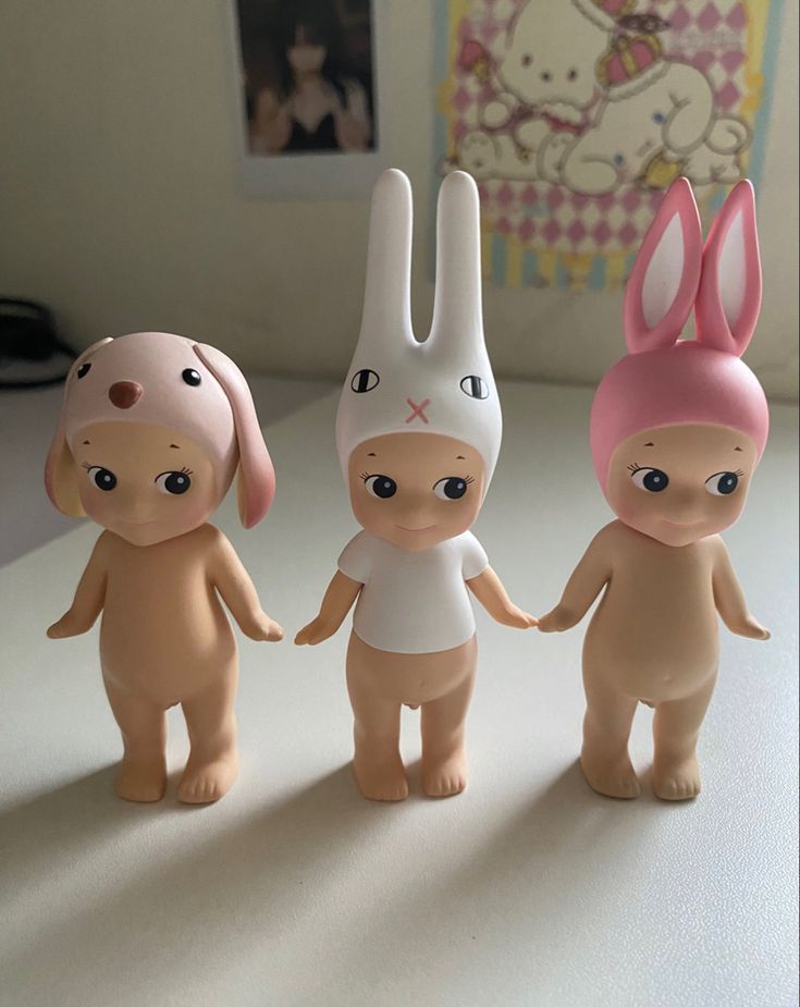 three little dolls are standing next to each other with bunny ears on their heads and legs