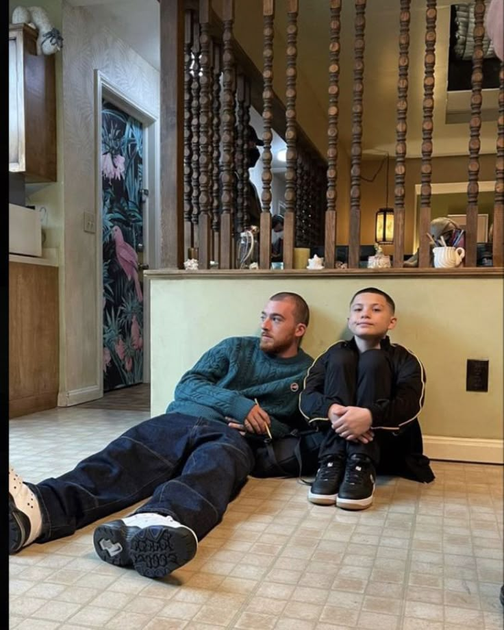 two men sitting on the floor with their feet up