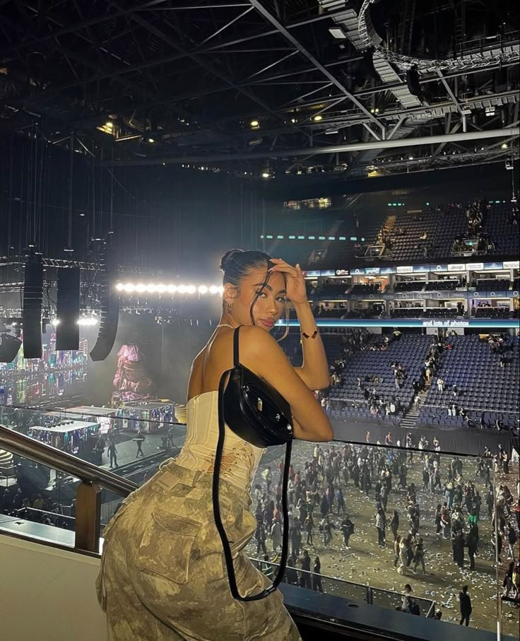 a woman standing in front of a crowd at a stadium