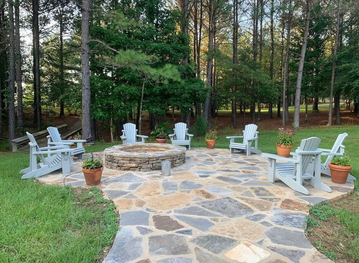 an outdoor fire pit surrounded by lawn chairs