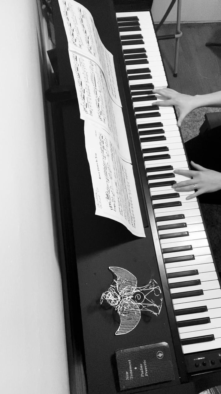 a person sitting at a piano with sheet music on it