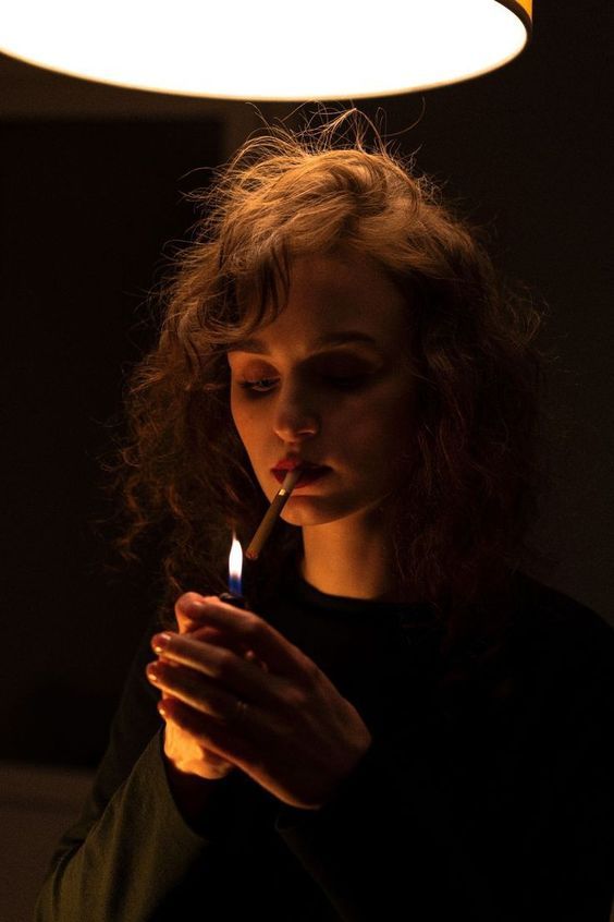 a woman holding a lit candle in her hands