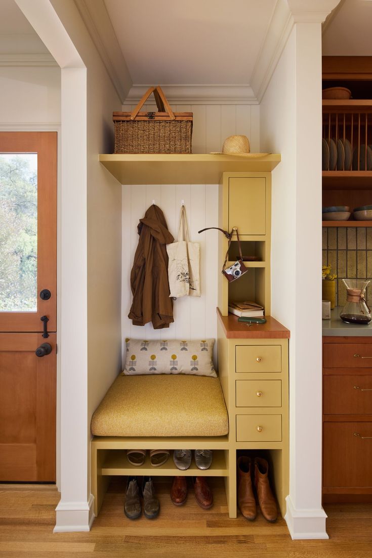 a yellow bench sitting in front of a wooden door next to a shelf filled with shoes