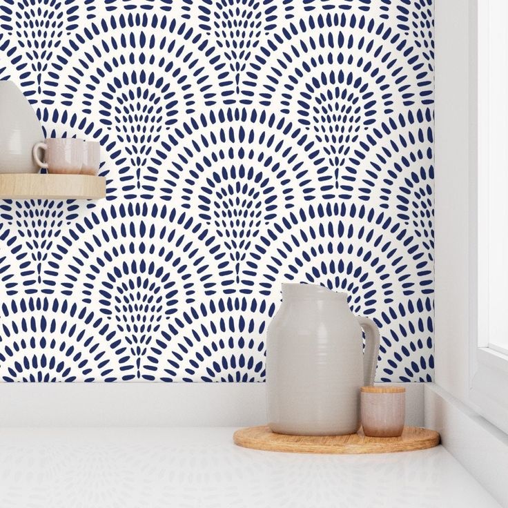 two vases are sitting on a shelf in front of a blue and white wall