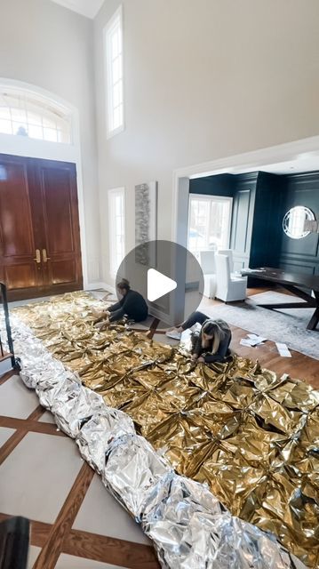 a living room filled with lots of gold foil on top of a hard wood floor