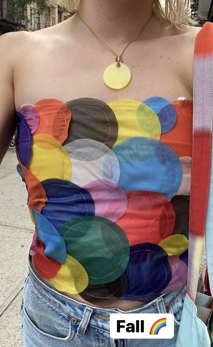 a woman wearing a colorful top with circles on it