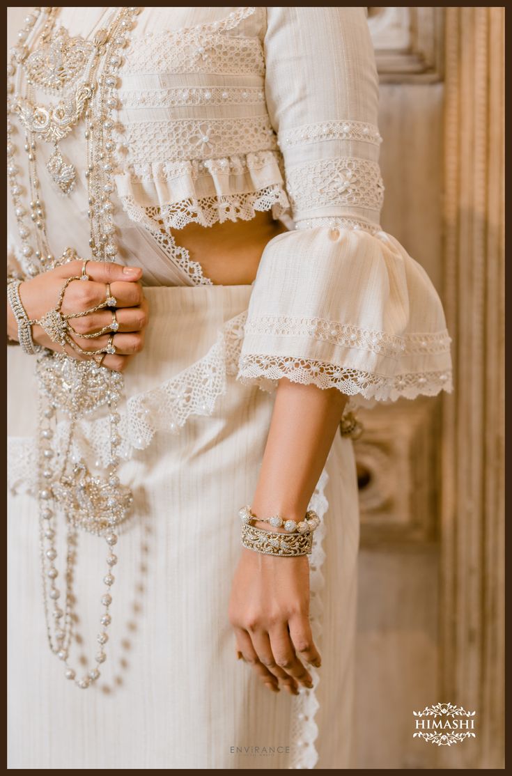 a woman in a white dress is wearing bracelets