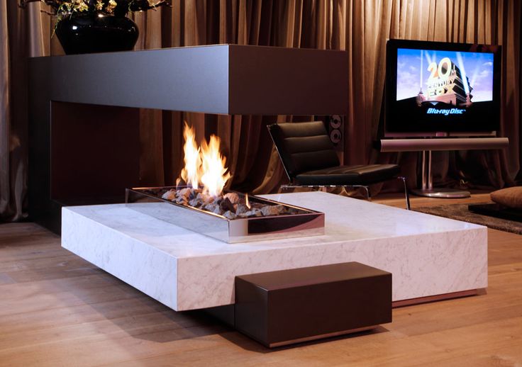 a living room with a television and fire pit in it's centerpieces