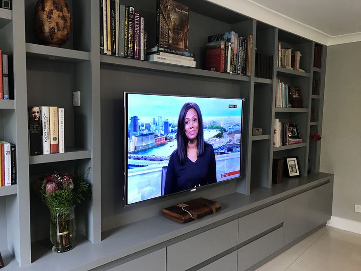 a flat screen tv sitting on top of a book shelf