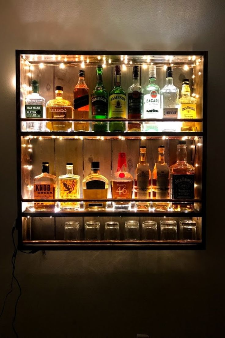 an illuminated liquor shelf filled with bottles and glasses