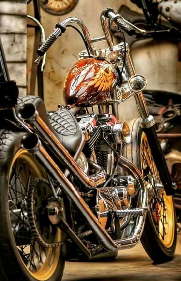 two motorcycles parked next to each other in a garage with gold rims on them