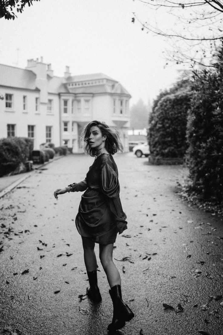 a woman is walking down the street in the rain