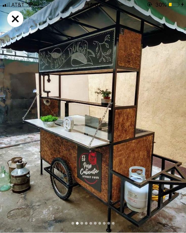 an old fashioned food cart is parked in front of a building