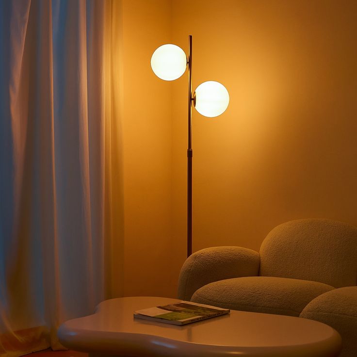 a living room with a couch, table and two lamps on the wall next to it