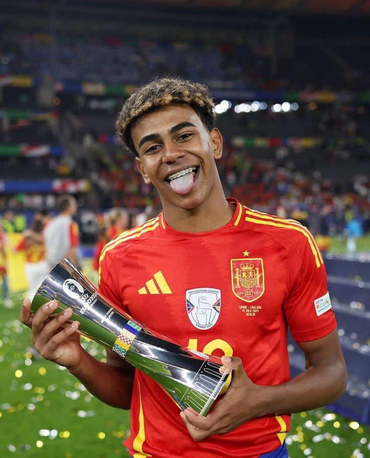 a soccer player holding a trophy in his hand