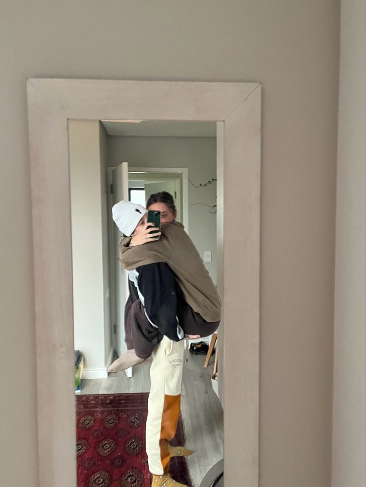 a man taking a selfie in front of a mirror with his back to the camera