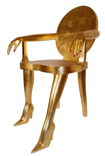 a gold colored chair with legs and hands on it's back, sitting in front of a white background