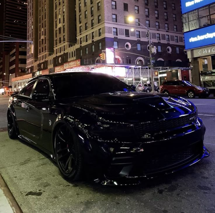 a black car is parked on the side of the street