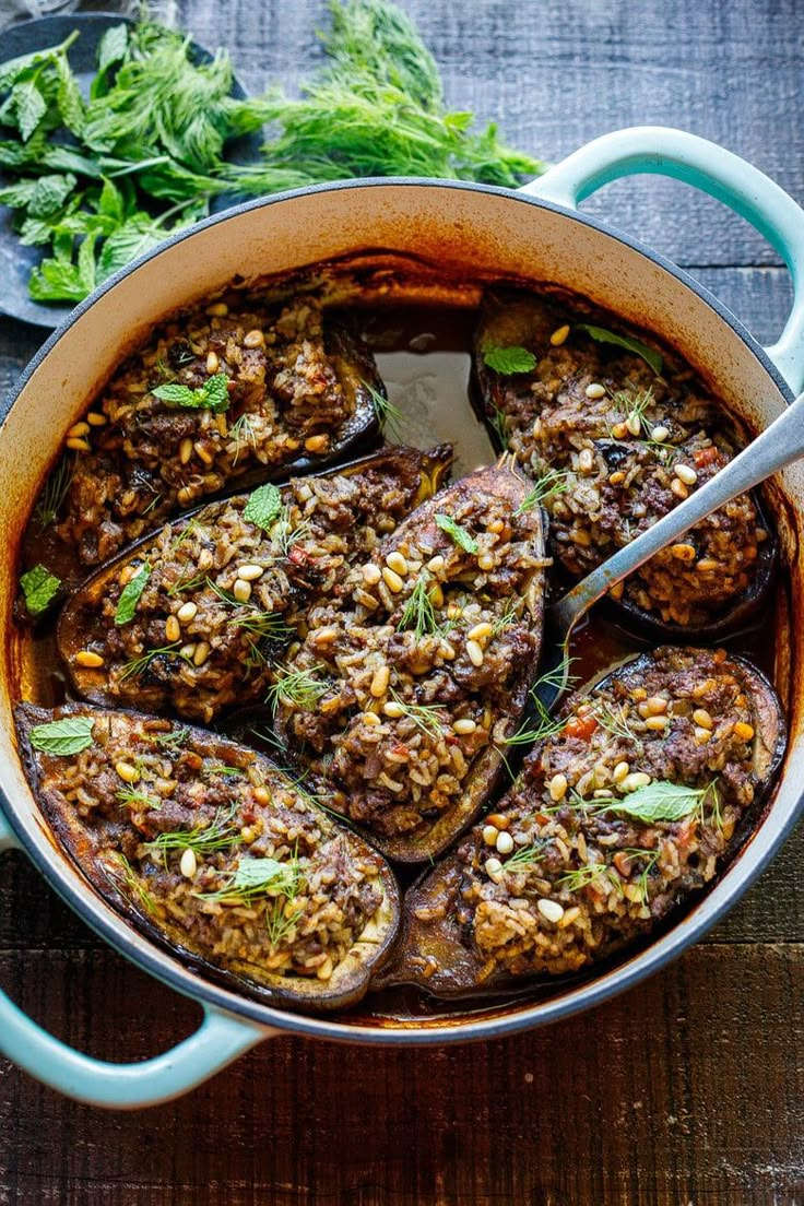 stuffed eggplant with lentils and herbs in a blue pot on a wooden table