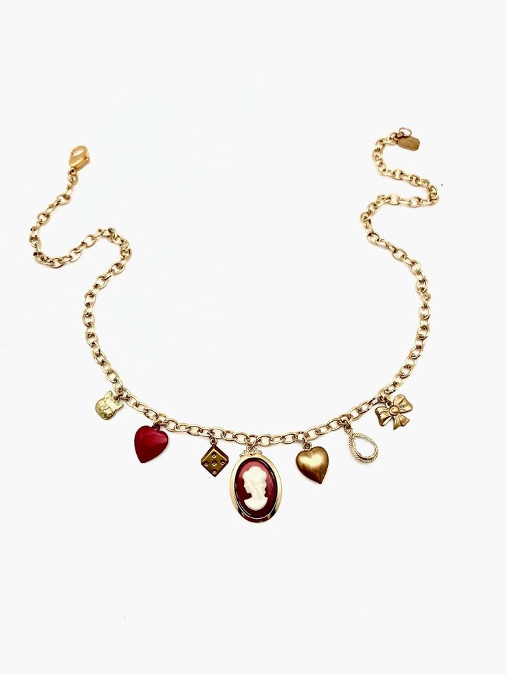 This charm necklace is the perfect mix of classic and trendy... made of mostly vintage charms on a vintage gold-plated chain, we can't even pick our favorite charm! 7 charms hang from this 18" vintage oval-cable chain: tiny brass cat face vintage powder-coated red heart vintage brass dice charm vintage glass/ gold plated cameo charm vintage brass puffy heart clear, natural quartz tear-drop shaped pendant, vermeil (18K gold plated) vintage brass bow Details: 18" in length, but can be clipped to w Cheap Vintage Heart Charm Jewelry, Vintage Charm Necklace With Heart Pendant, Luxury Oval Necklace With Vintage Charm, Luxury Vintage Charm Necklaces, Luxury Vintage Charm Round Necklaces, Elegant Heart-shaped Charm Necklace With Vintage Charm, Heart-shaped Vintage Charm Necklaces, Vintage Heart-shaped Necklace With Vintage Charm, Brass Bow