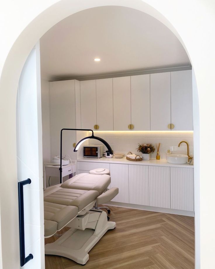 an open doorway leading into a room with white furniture and wood flooring on the walls