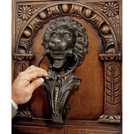 a person is opening the door with a lion head knocket in front of them