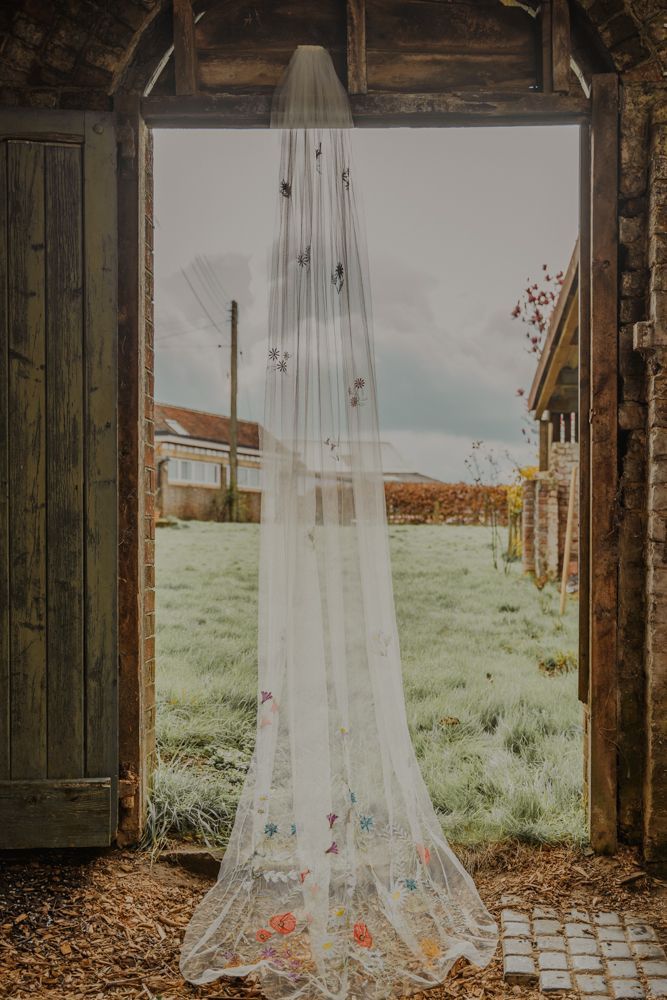 an open door with a white veil hanging from it's side in front of a field