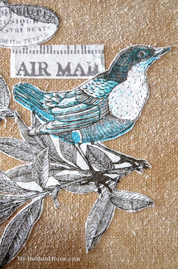 a bird sitting on top of a tree branch with leaves around it and an air mail sign in the background