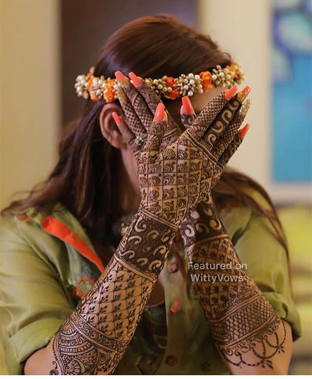 a woman is holding her hands up to her face with henna designs on it