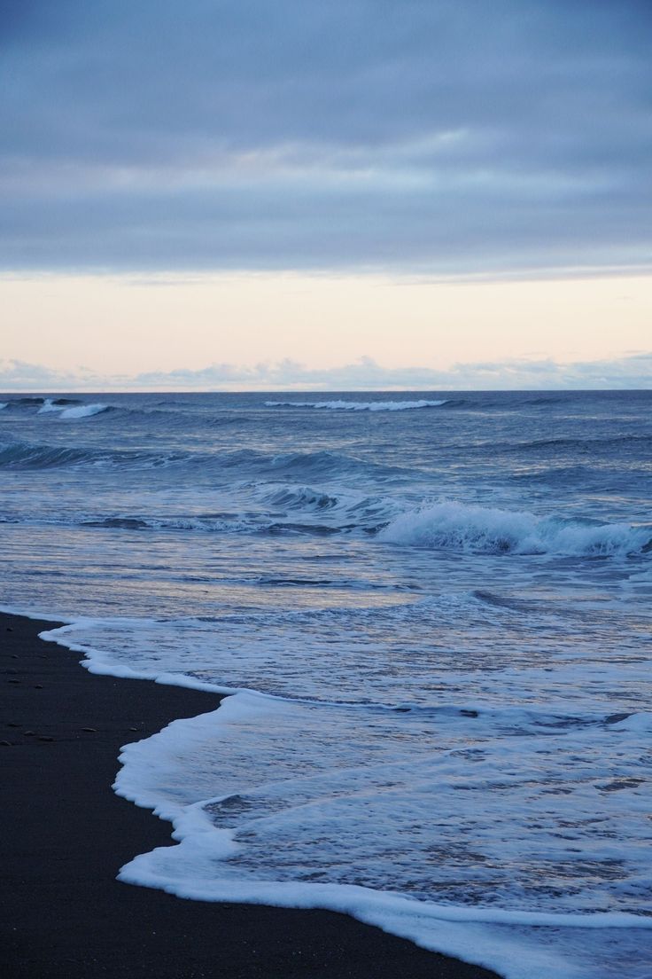 the ocean waves are rolling in to shore