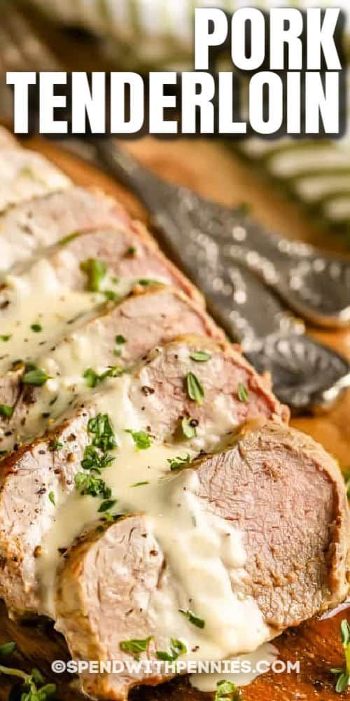 sliced pork tenderloin on a cutting board with gravy and parsley