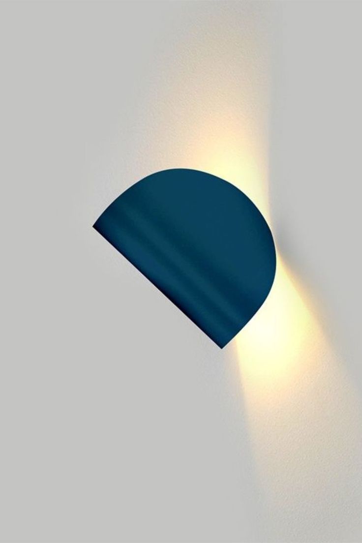 a wall light with a blue shade on it's side and a white background