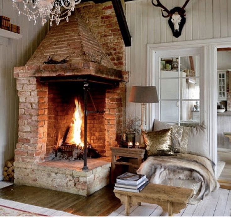 a living room filled with furniture and a fire place in the middle of it's fireplace