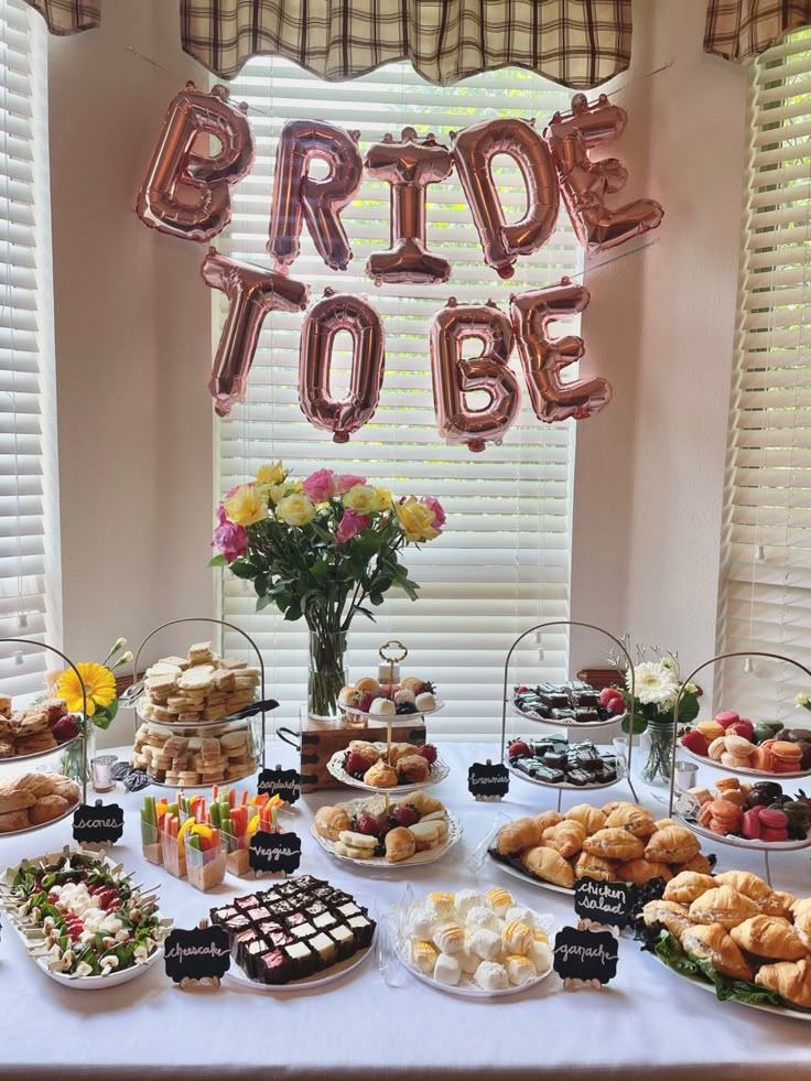 a table topped with lots of desserts next to a sign that says bride to be