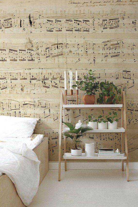 a bedroom with sheet music wallpaper and plants on the shelf in front of the bed