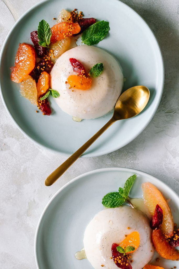 two white plates topped with desserts on top of a table