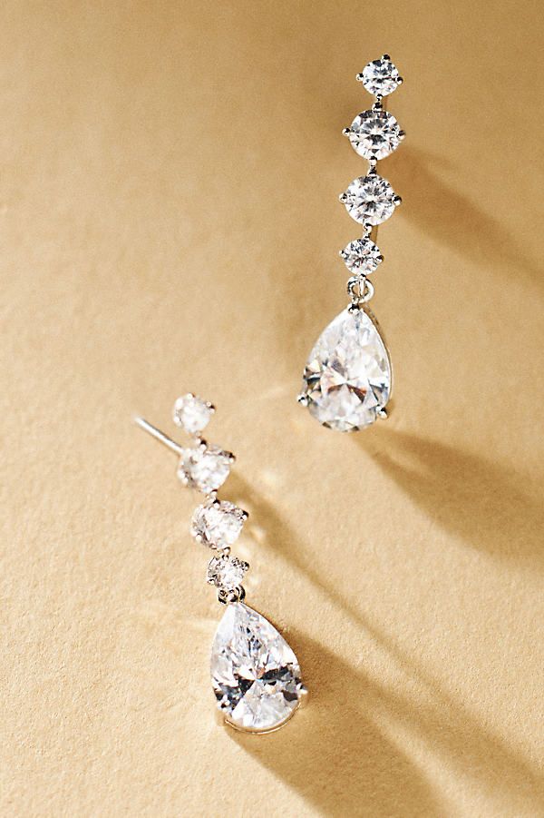 These stunningly luminous drop earrings by NADRI offer the perfect touch of glamour, featuring a line of radiant stones culminating in a larger pear-shaped gem. | Crystal Drop Earrings by NADRI in Silver, Women's, Gold/Plated Brass/Cubic Zirconia at Anthropologie Wedding Earrings Elegant, Bridesmaid Jewelry Silver, Dimond Earrings, Silver Wedding Earrings, Ethereal Earrings, Statement Earrings Wedding, Crystal Bridal Earrings, Bridal Accessories Jewelry, Bridal Earrings Drop