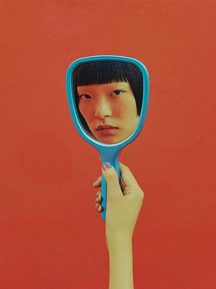 a person holding up a mirror to their face