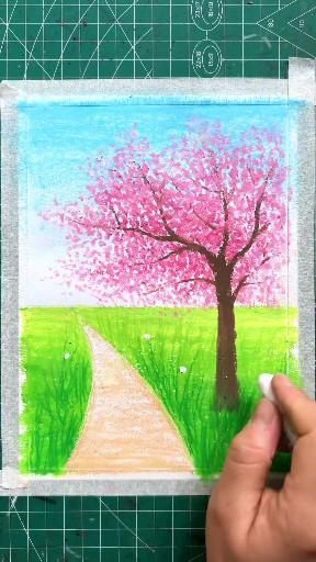 someone is drawing a tree with colored pastel pencils on a piece of paper