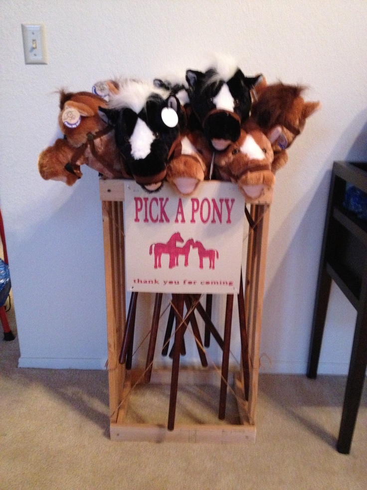 there is a sign that says pick a pony with stuffed animals on it in the corner