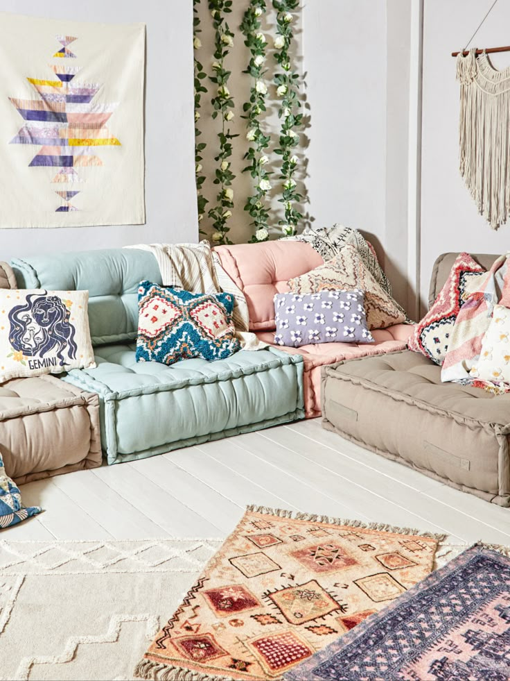 a living room filled with lots of pillows and rugs