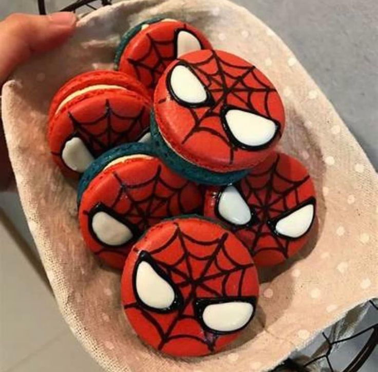 spiderman cookies on a plate with white icing