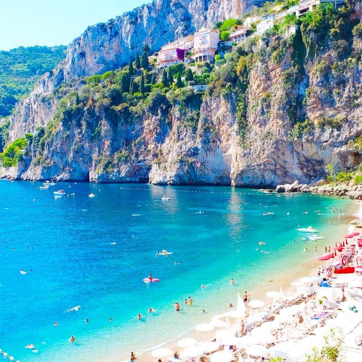 the beach is crowded with people and umbrellas