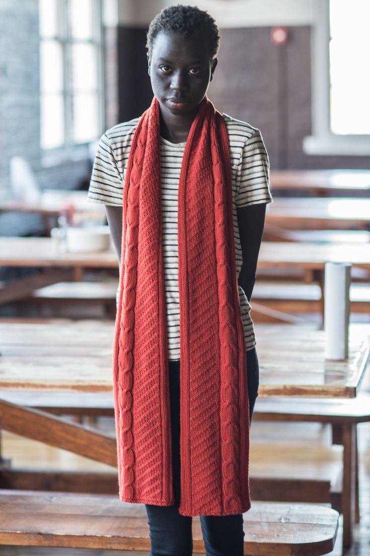 a woman standing in front of a table wearing a red scarf