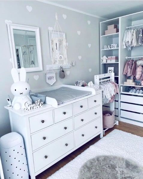 a baby's room with lots of white furniture